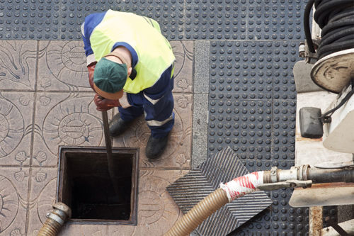 Technician performing drain cleaning service