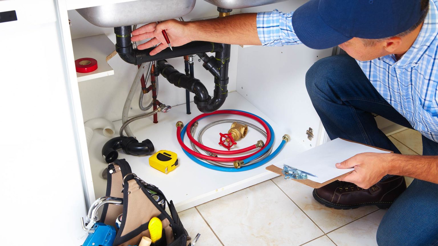 Licensed plumber fixing kitchen sink in Bergen County home